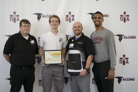 Kade Bleakley with, from left, North Oaks Sports Medicine Athletic Trainer Jeremy Kulbeth and Head Athletic Trainer/Supervisor Matthew Rabalais, and Falcons Head Basketball Coach Raymone Andrews.